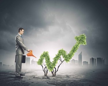 man in coat watering upward arrow plant