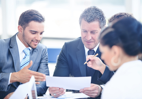 manager and employees reviewing paperwork