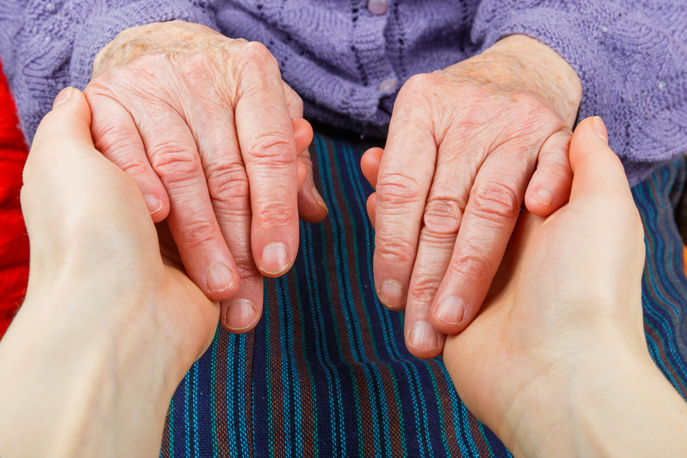 younger person holding the hands of an older person