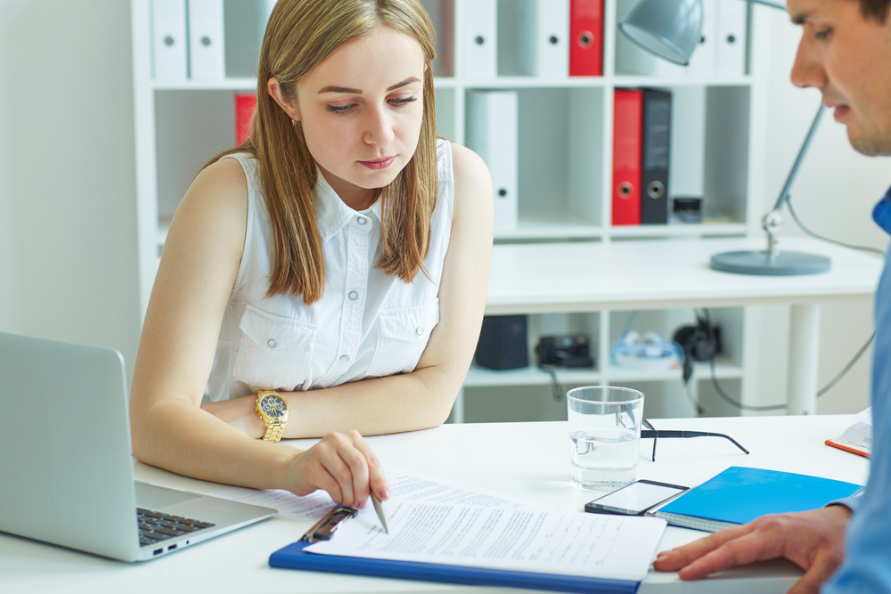 Female and male staffing agency employee meeting at desk